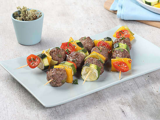 Skewers of aromatic meatballs and vegetables